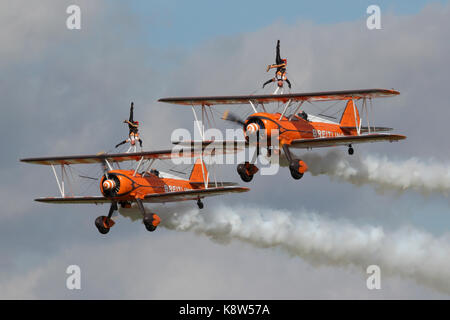 Die AeroSuperBatics Boeing Stearmans mit wingwalkers sie an einer rougham Airshow in Suffolk, Großbritannien. Stockfoto