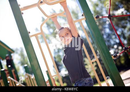 Aktive kleines Mädchen auf dem Spielplatz Stockfoto