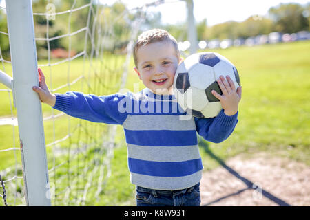 Junge mit Fußball im Park Stockfoto