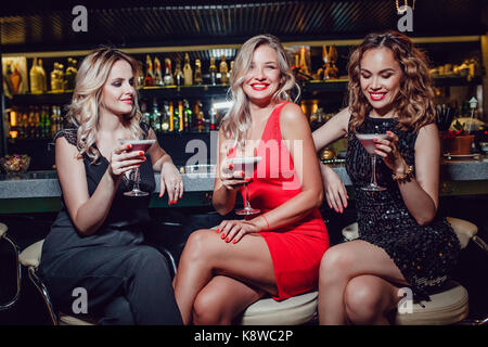 Schöne Frauen sitzen an der Bar und tranken Cocktails. Stockfoto