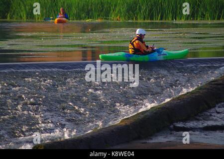 Kajakfahrer verhandeln Trews Wehr auf dem River Exe. Exeter, Devon, Großbritannien. August, 2017. Stockfoto