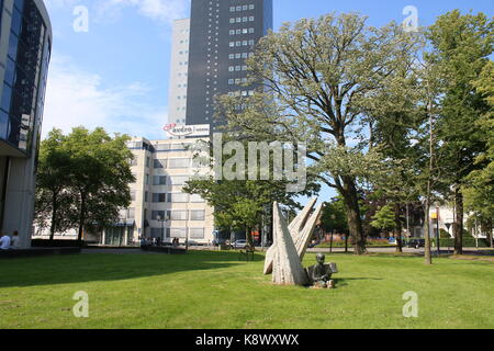 Kleiner Park mit Skulpturen von spielen Junge. Im Hintergrund 115 m hohen Achmeatoren (Achmea Turms Büros.) Höchste Gebäude in Leeuwarden, Niederlande. Stockfoto