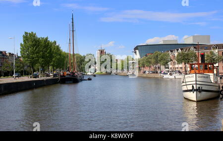 Traditionelle Segelschiffe entlang Westersingel Kanal im Zentrum von Leeuwarden, Friesland, Niederlande vertäut. Im Hintergrund iconic Oldehove Tower. Stockfoto