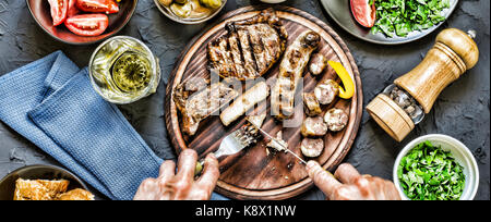 Der Mensch isst ein saftiges Steak grillen. film Effekt Stockfoto