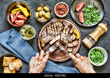 Der Mensch isst ein saftiges Steak grillen. film Effekt Stockfoto