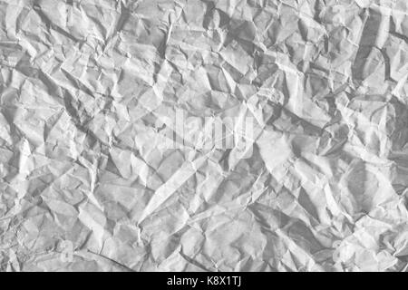 Oberfläche der zerknittertes Papier durch Licht hervorgehoben. Betont, beleuchtete Blatt Papier. Stockfoto