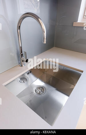 Weiße Küche mit grauen backsplash, Waschbecken und Induktionsherd