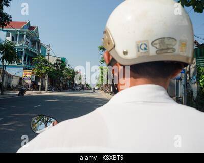 Hue, Vietnam - 13. September 2017: unbekannter Mann mit einem weißen Helm, Motorrad fahren auf der Straße in der Stadt Hue, Vietnam Stockfoto