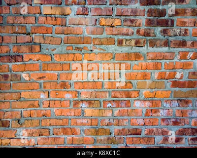 Eine Nahaufnahme eines groben Mauerwerk Wand mit roten ungeschickt Ziegel für die Kreativität, Texturen und Hintergründe gesäumt. Stockfoto