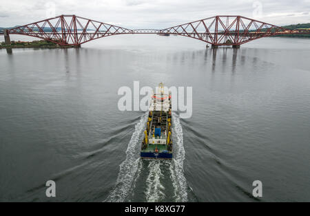 UKD Orca, ein Sog hopper Schwimmbagger segeln in Richtung Ausleger Forth Rail Bridge in ruhigem Wasser, Erhabene, Schottland, Großbritannien Stockfoto