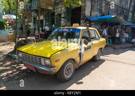 Gelbes Taxi Parken auf der Straße in Yangon, Myanmar, Asien Stockfoto