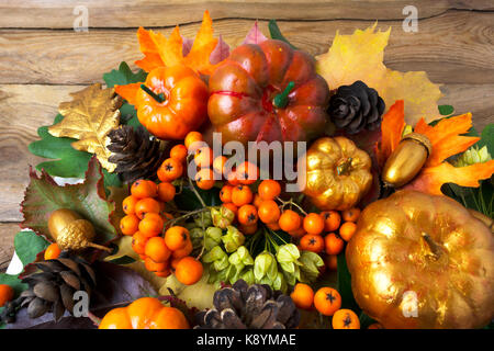 Herbst grün mit goldenen Kürbisse und Eicheln auf dem alten Holztisch, Ansicht von oben. Danksagung Hintergrund mit Beeren und Zapfen Kranz Stockfoto