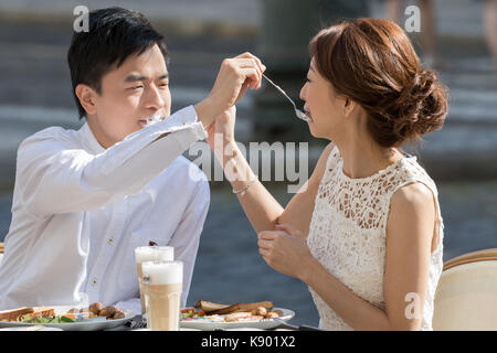 Prag, Tschechische Republik - 19 August 2017: Paar Liebhaber spielen mit schmutzigen cappuccino Creme untertassen am Tisch ein Cafe sitzen Stockfoto