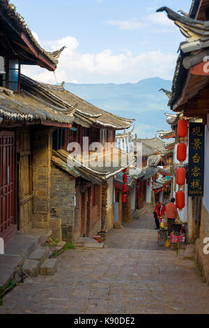 Lijiang, China - 21. September 2017: eine schmale, Abschüssige Gasse mit wunderschön erhaltenen traditionellen chinesischen Architektur und Berg Hintergrund in Li Stockfoto