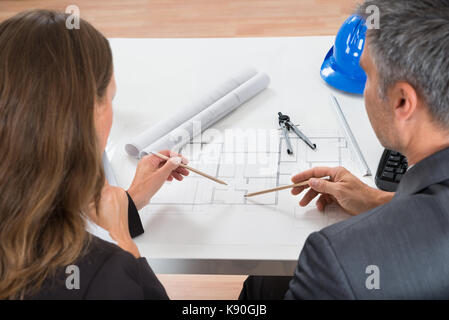 In der Nähe von zwei Geschäftsleute arbeiten an Blueprint im Büro Stockfoto