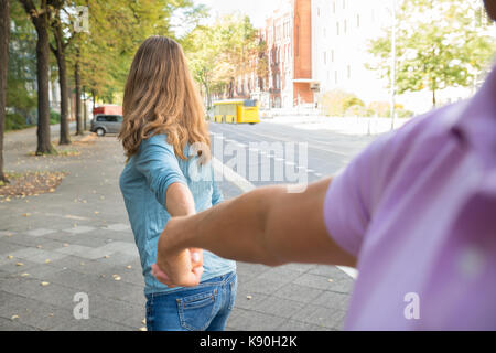 Frau mit Händen des Menschen beim Gehen auf dem Bürgersteig Stockfoto