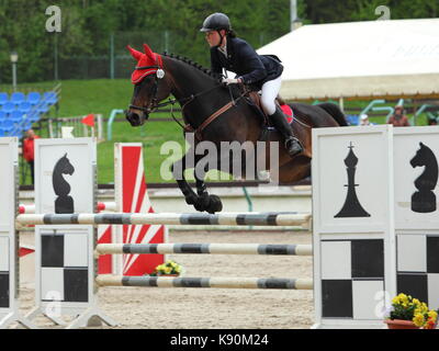 Junges Mädchen auf dem Pferd bei Springprüfung Stockfoto