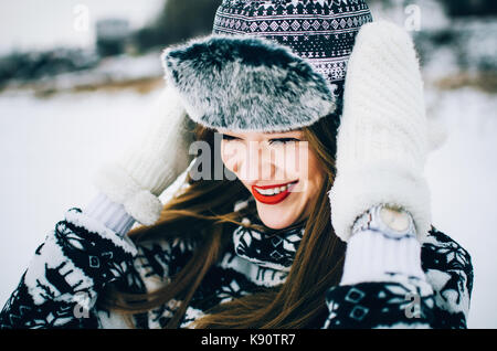 Portrait von gutaussehenden jungen Frau trägt warme Mütze und Handschuhe im Winter. Stockfoto