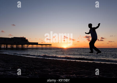 Aberystwyth Wales UK, Donnerstag, den 21. September 23017 UK Wetter: Am Vorabend der Herbst-tagundnachtgleiche, Jesse stecken, ein 3. Jahr Student Studium der Astrophysik an der Universität Aberystwyth, Praktiken seiner Slack-line Fähigkeiten, wie die Sonne über dem Meer setzt auf aberystwyth an der Küste von West Wales Photo Credit: Keith Morris/Alamy leben Nachrichten Stockfoto