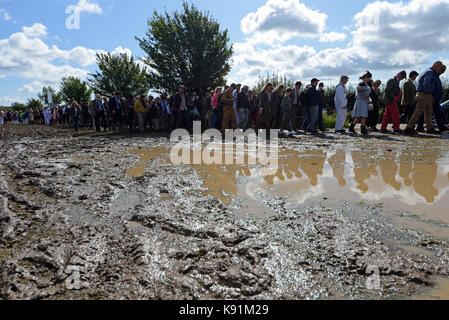 Die Menge steht im Schlamm, um Goodwood Revival 2017 zu erleben. Pfützen. Schlammig. Regenwasser. Ungünstiges Wetter, Widrigkeiten überwinden. Wetter hat Auswirkungen auf das Ereignis im Freien Stockfoto