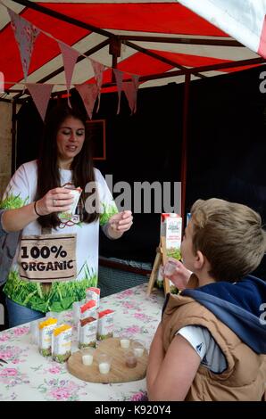 Abschaltdruck Halter bietet ein Junge eine Stichprobe von Daioni organische Milchshake Abergavenny Food Festival Monmouthshire Wales Cymru GROSSBRITANNIEN GB Stockfoto