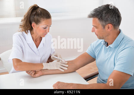 Porträt der Arzt das Blut von Patienten mit Spritze im Krankenhaus Stockfoto