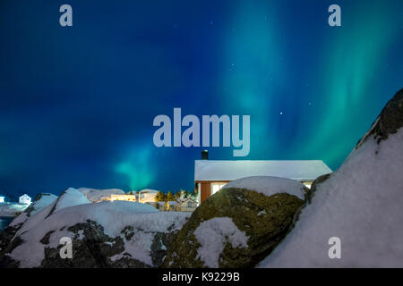 Norwegen. Lofoten. Winter Hamnoy. Nordlicht über den Dächern der Häuser Stockfoto