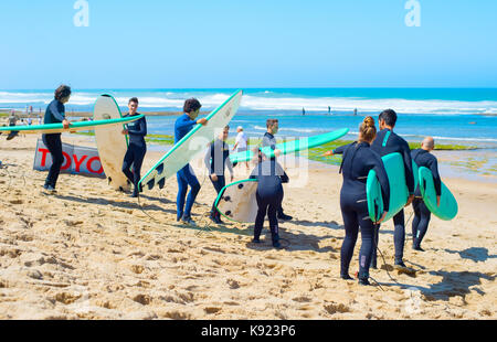 ERICEIRA PORTUGAL - May 23, 2017: Gruppe der Surfer mit Surfboards zum Wellenreiten. Ericeira ist der berühmte Surfen in Portugal. Stockfoto