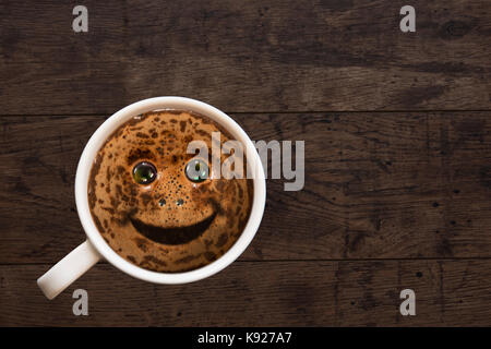 Die duftenden schwarzen Kaffee in einer Porzellan Schale auf einem Hintergrund aus Holz mit einem Lächeln Stockfoto