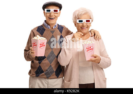 Senioren mit 3D-Brillen und Popcorn an der Kamera auf weißem Hintergrund suchen Stockfoto