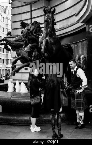 Eine weibliche Touristen im Chat mit einem Street Entertainer, Piccadilly Circus, London, UK Stockfoto