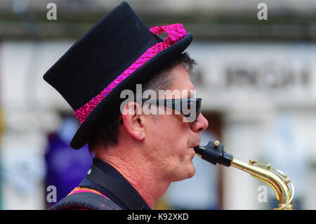 Männliche Musiker aus dem passgang Band Saxophon am Grassmarket während des Edinburgh International Fringe Festival, Schottland, Großbritannien Stockfoto