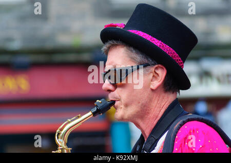 Männliche Musiker aus dem passgang Band Saxophon am Grassmarket während des Edinburgh International Fringe Festival, Schottland, Großbritannien Stockfoto