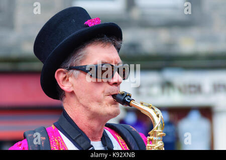 Männliche Musiker aus dem passgang Band Saxophon am Grassmarket während des Edinburgh International Fringe Festival, Schottland, Großbritannien Stockfoto