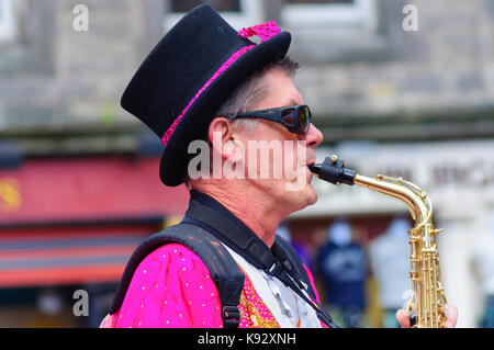 Männliche Musiker aus dem passgang Band Saxophon am Grassmarket während des Edinburgh International Fringe Festival, Schottland, Großbritannien Stockfoto