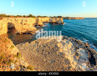 Malerische Meereslandschaft mit Klippen, felsigen Arch und Stapel (Faraglioni), bei Torre Sant Andrea in der Morgensonne, Salento Küste, Apulien, Italien Stockfoto