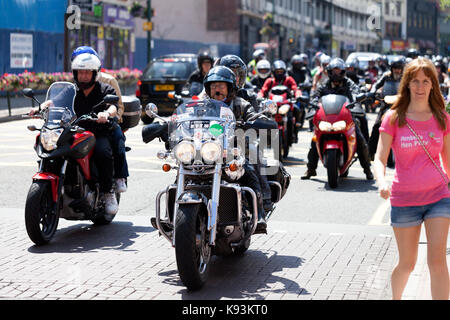 Eine große Gruppe oder Bande von Bikern, die ihre Fahrräder durch das Stadtzentrum von Birmingham fahren, einer benutzt ein Trike Stockfoto