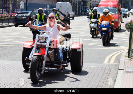 Eine große Gruppe oder Bande von Bikern, die ihre Fahrräder durch das Stadtzentrum von Birmingham fahren, einer benutzt ein Trike Stockfoto