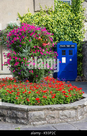 Eine Blaue Polizei öffentlichen Telefon in einem kleinen Garten in der High Street in Pateley Bridge North Yorkshire England Vereinigtes Königreich Großbritannien Stockfoto