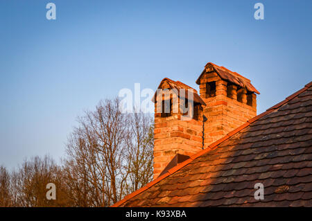 Zwei rote Backstein Schornsteine gegen den blauen Himmel Hintergrund Stockfoto