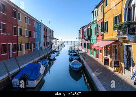 Kleine Motorboote in schmalen Kanal Linien mit bunten Häusern festgemacht, Venedig, Italien. Stockfoto