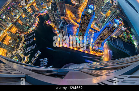 Luftaufnahme von das Stadtbild von Dubai, Vereinigte Arabische Emirate bei Dämmerung, mit beleuchteten Wolkenkratzer und den Jachthafen im Vordergrund. Stockfoto