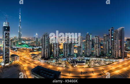 Das Stadtbild von Dubai, Vereinigte Arabische Emirate. bei Dämmerung, mit beleuchteten Wolkenkratzer im Vordergrund. Stockfoto