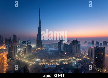 Das Stadtbild von Dubai, Vereinigte Arabische Emirate bei Dämmerung, mit dem Burj Dubai Wolkenkratzer und beleuchteten Gebäuden im Vordergrund. Stockfoto