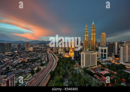 Stadtbild von Kuala Lumpur, Malaysia in der Dämmerung, mit beleuchteten Petronas Towers in der Ferne. Stockfoto