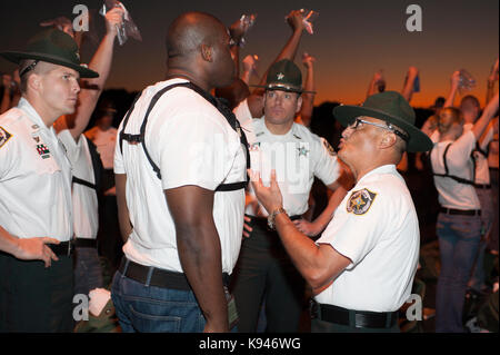 Mehrere Sheriff stellvertretender drill Instructors motivieren eine Polizeiakademie Cadet während der ersten Phase der Schulung im Bereich Strafverfolgung. Florida USA. Stockfoto