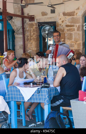 Lokale Mann spielt das Akkordeon in einem der Restaurants im venezianischen Hafen von Chania. Kreta, Griechenland Stockfoto