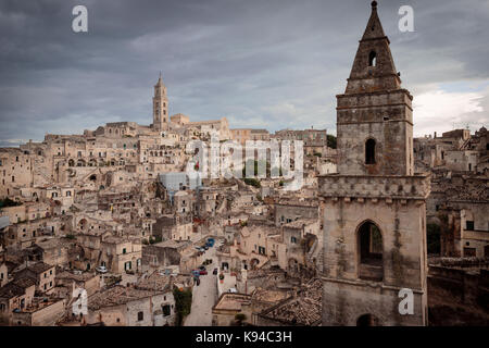 Der Glockenturm und die Kirche von San Pietro Barisano und die civita mit der Kathedrale, Sassi di Matera, Basilikata, Italien. Stockfoto