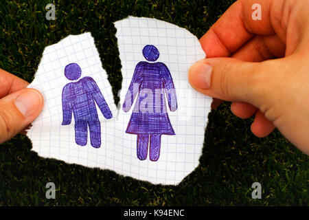 Frau händigt mit handgezogenen Mann- und Frauenfiguren ein Stück Papier aus. Grashintergrund. Doodle-Stil. Stockfoto