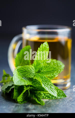 Lecker Pfefferminztee. Minzeblättchen und Kaffee Tasse. Stockfoto